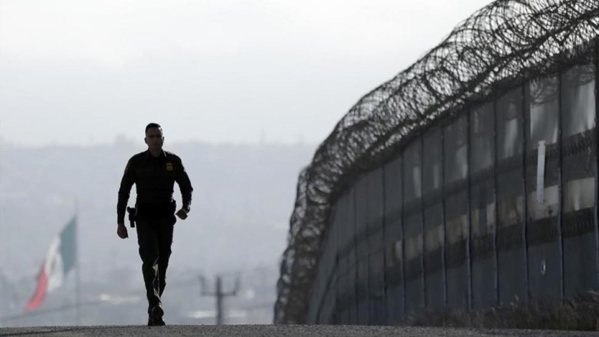 Un agente patrulla la valla que separa México y San Diego.-AP / GREGORY BULL