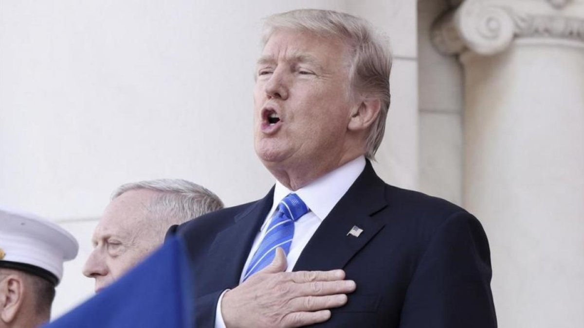 Trump canta el himno nacional antes de su discurso, en Arlington (Virginia), el 29 de mayo.-OLIVIER DOULIERY