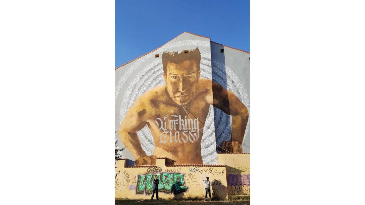Los artistas Chais Martín y Rubén Casassola posan en el mural de calle Guardería (paseo Arco de Ladrillo). EVA MARTÍNEZ