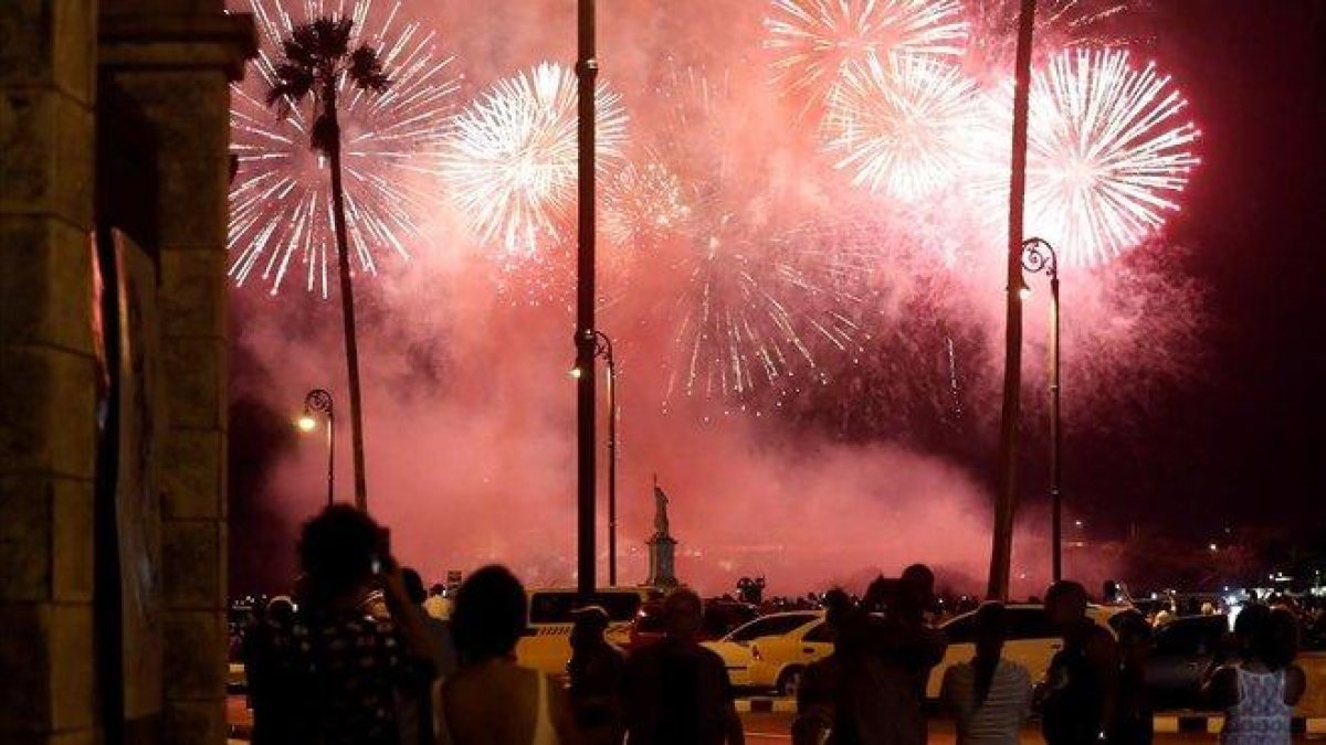 Varias personas observan este sabado el lanzamiento de los fuegos artificiales con motivo de la celebración de los 500 años de la fundacion de La Habana.-EFE / ERNESTO MASTRASCUSA