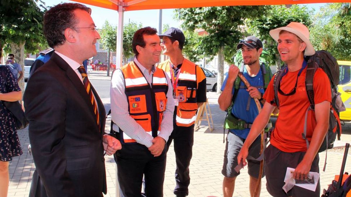 El concejal de Seguridad y Movilidad de León, Fernando Salguero (I), conversa con dos peregrinos norteamericanos durante la presentación de la campaña-Ical
