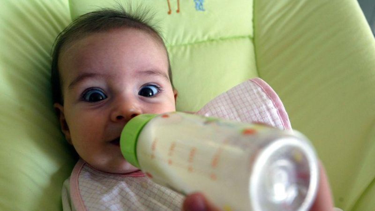 Un bebé tomando el biberón.-JULIO CARBO