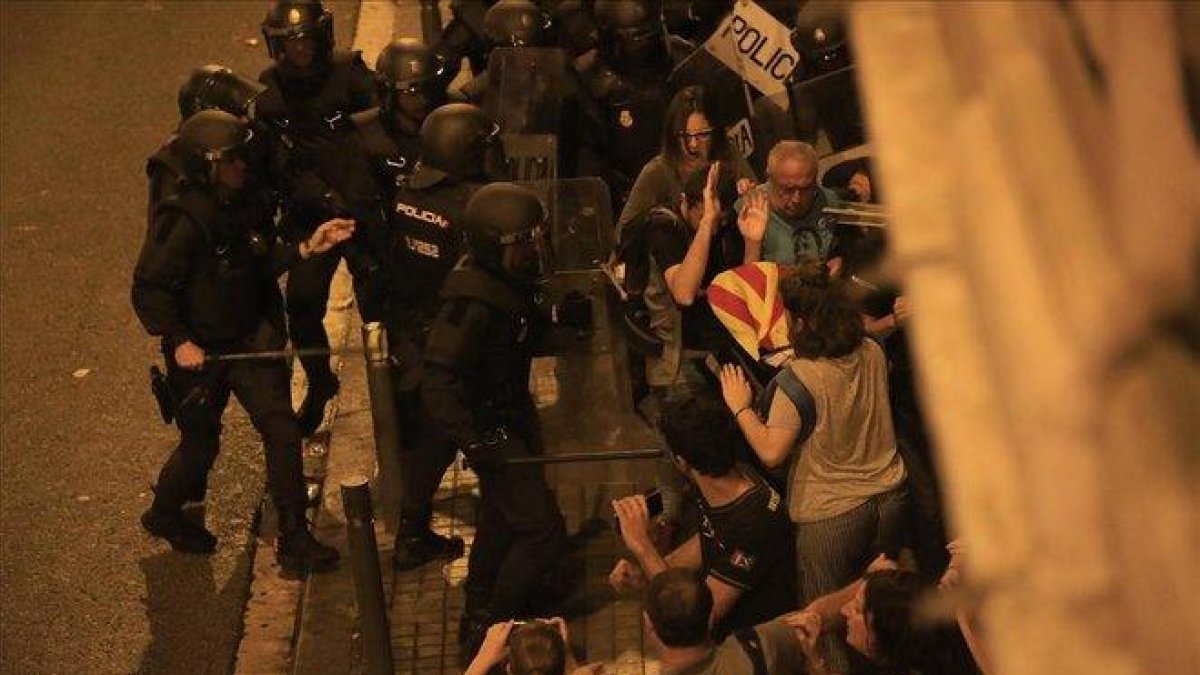Los antidisturbios de los Mossos contienen a manifestantes en la Vía Laietana de Barcelona, junto a la comisaría de la Policía Nacional.-FERRAN NADEU