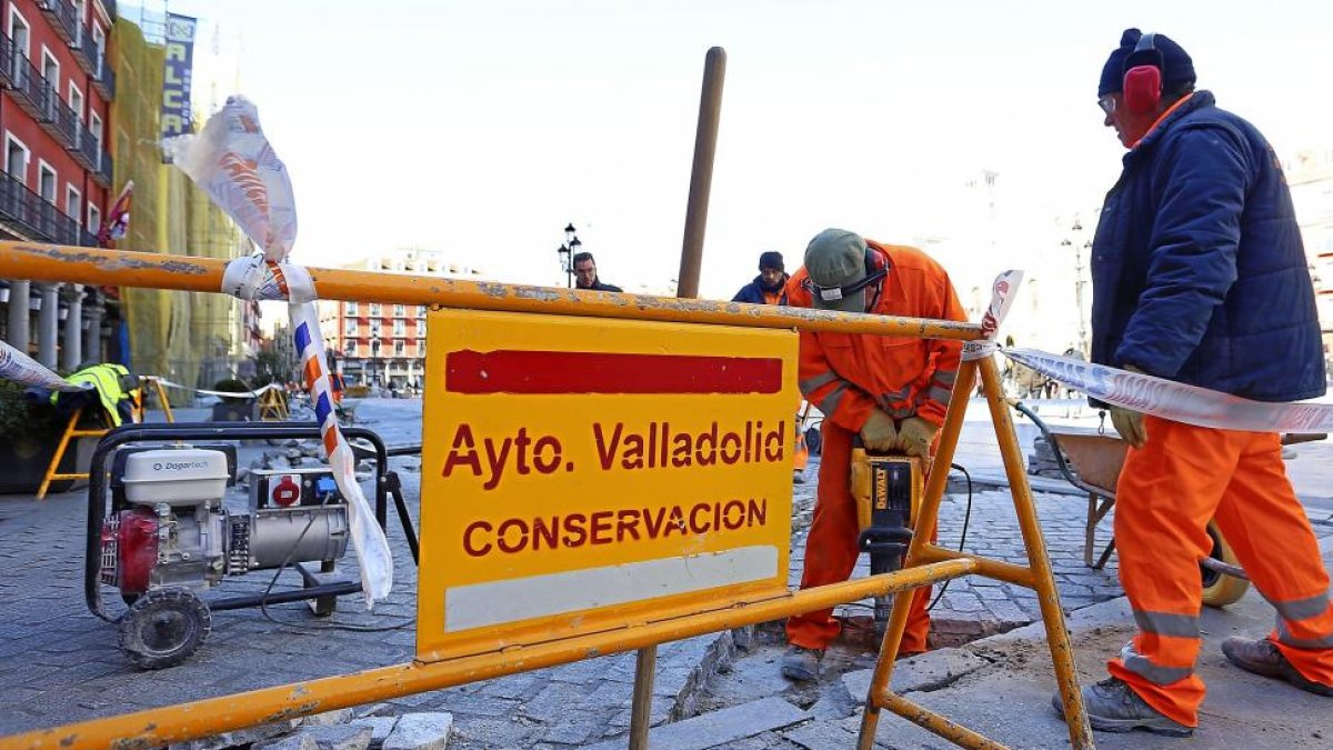 Un operario trabaja, ayer, en la reparación del pavimento adoquinado de la Plaza Mayor.-ICAL