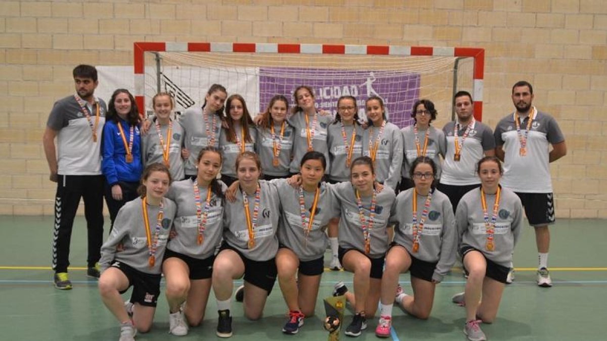 El equipo infantil del HandVall, junto a sus entrenadores, posan con las medallas de bronce.-EL MUNDO