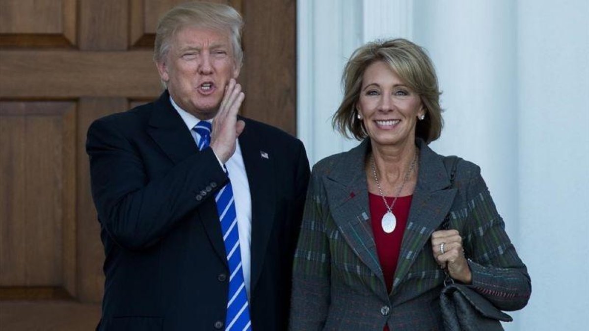 Betsy DeVos (derecha) junto a Trump en Nueva Jersey, el 18 de noviembre.-AFP / DREW ANGERER