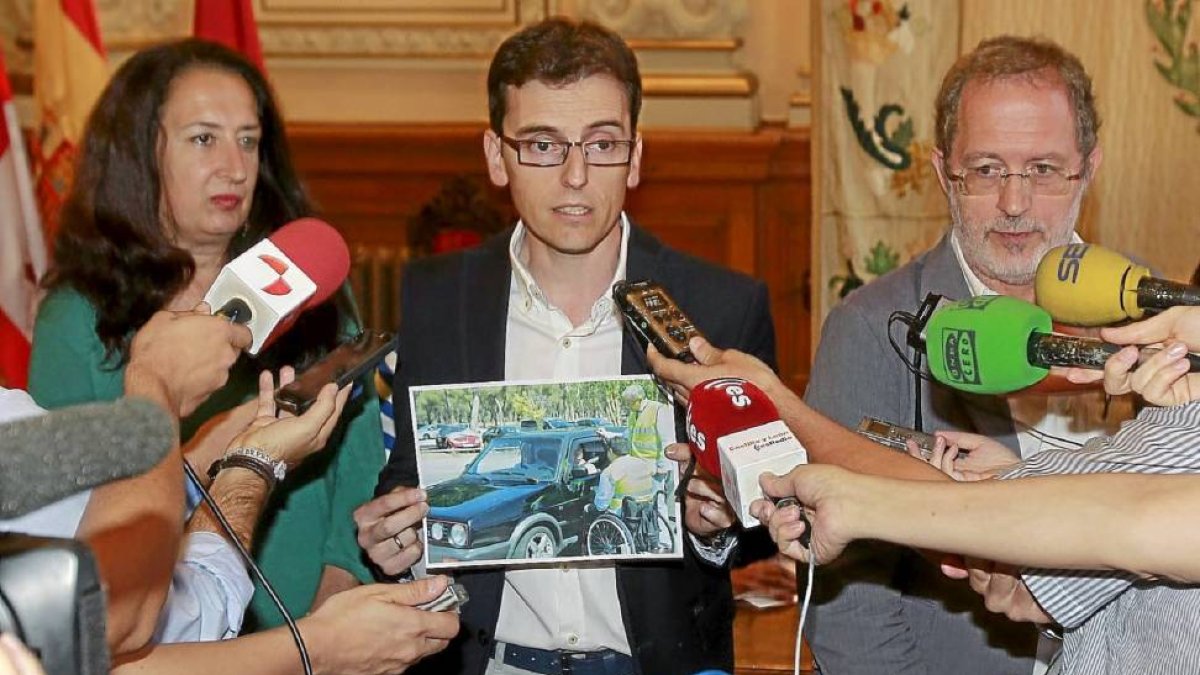 El portavoz del PSOE sostiene una foto del ex subdelegado del Gobierno en la que aparece durante una campaña de seguridad vial.-J.M. Lostau