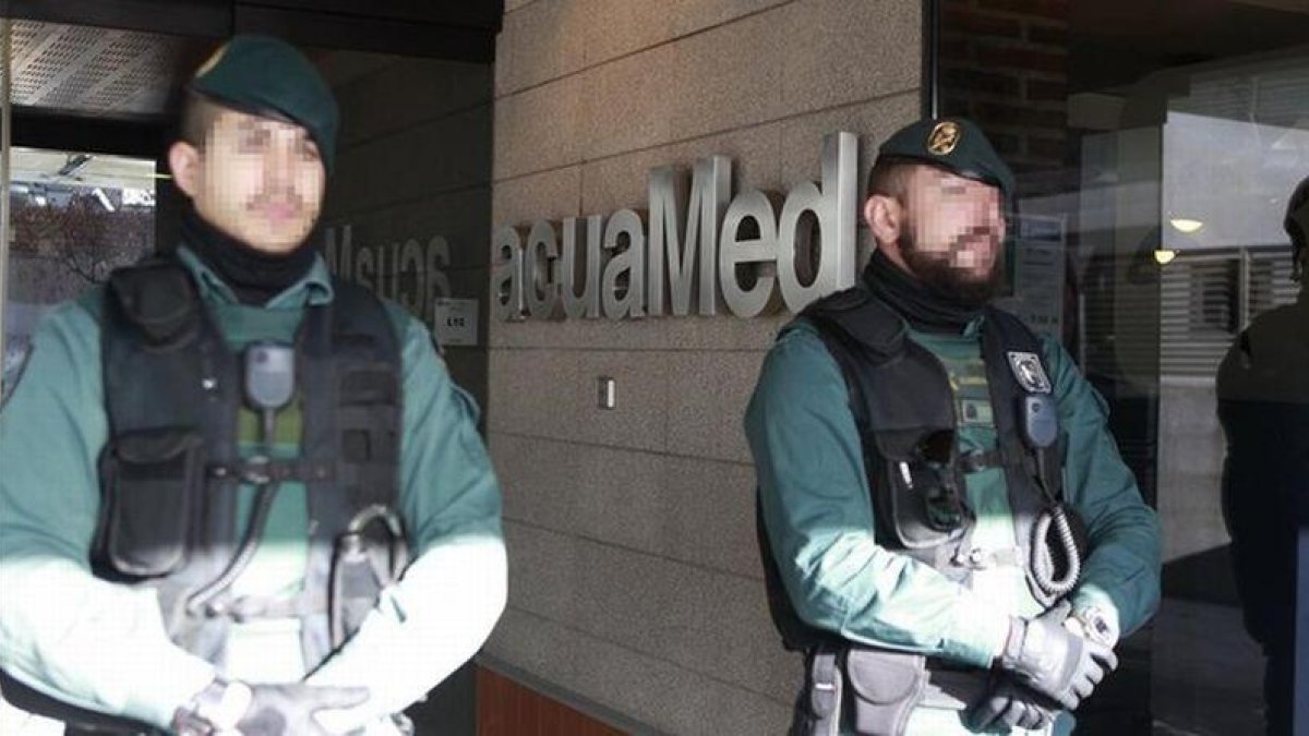 Agentes de la Guardia Civil custodian la sede de la empresa pública Aguas de las Cuencas Mediterráneas (Acuamed), en Madrid, durante el registro de las dependencias.-EFE / VÍCTOR LERENA