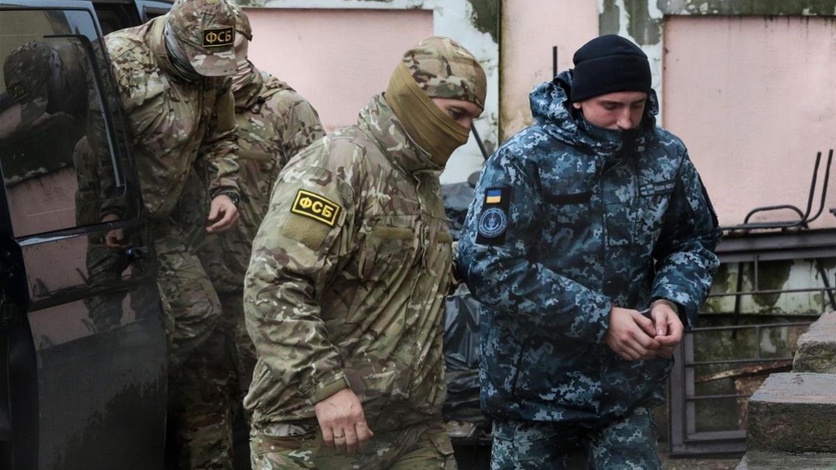 Militar ruso conduce a uno de los marineros detenidos-AFP