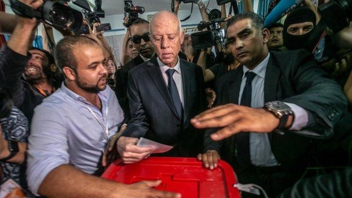 El candidato islamista Kais Saied, en el centro, votando en los comicios.-DPA / KHALED NASRAOUI