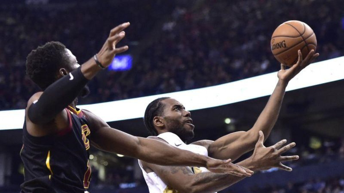 Kawhi Leonard, conducen a la derecha a la canasta, mientras que la escolta de los Cleveland Cavaliers, Rodney Hood, definitivamente a la izquierda durante la segunda mitad del partido de baloncesto de la NBA.-THE CANADIAN PRESS