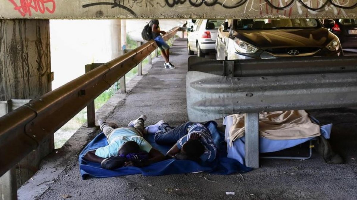 Inmigrantes duermen bajo un puentre en Ventimiglia, en el noroeste de Italia, junto a la frontera francesa, el 14 de junio.-/ AFP / MIGUEL MEDINA