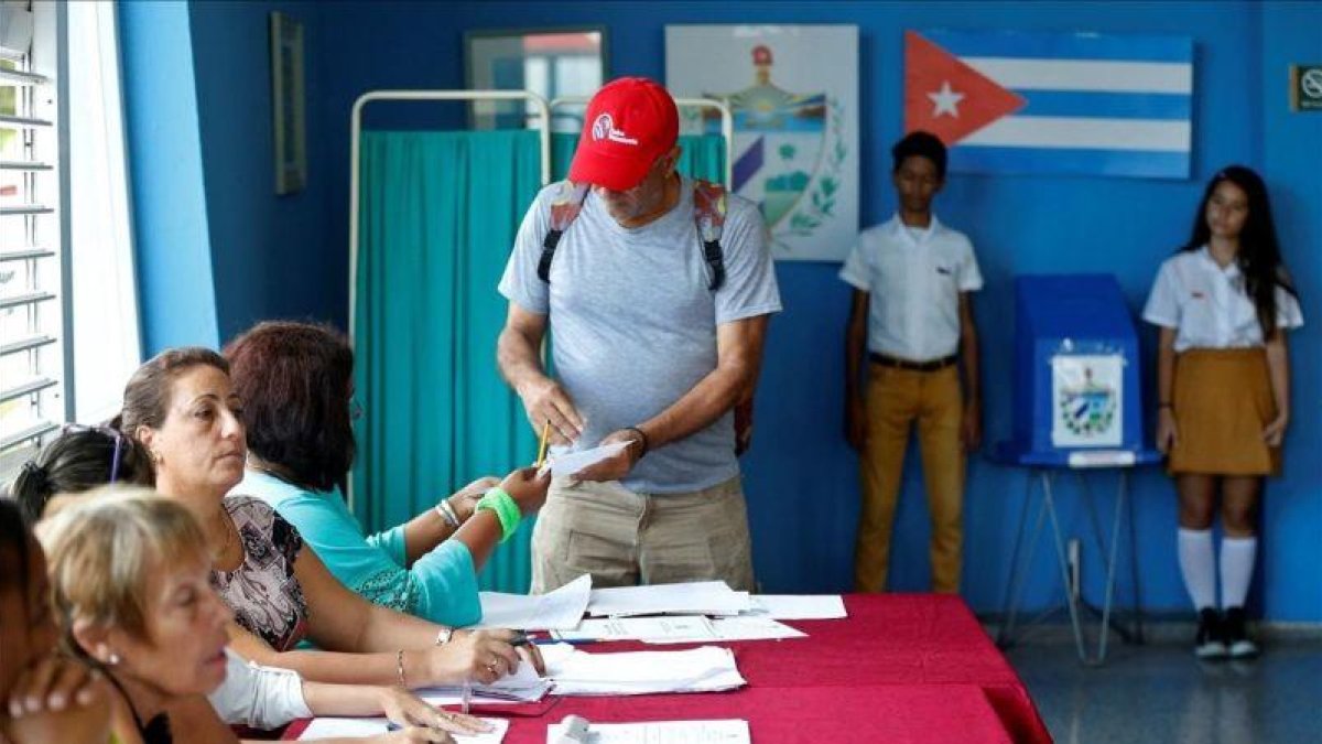 Un elector deposita su voto el domingo en un colegio electoral de La Habana.-EFE / ERNESTO MASTRASCUSA