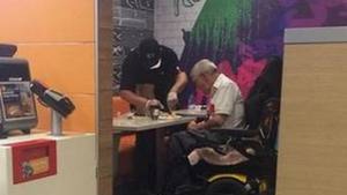 El empleado conocido como 'Kenny', mientras ayuda a un discapacitado.-FACEBOOK