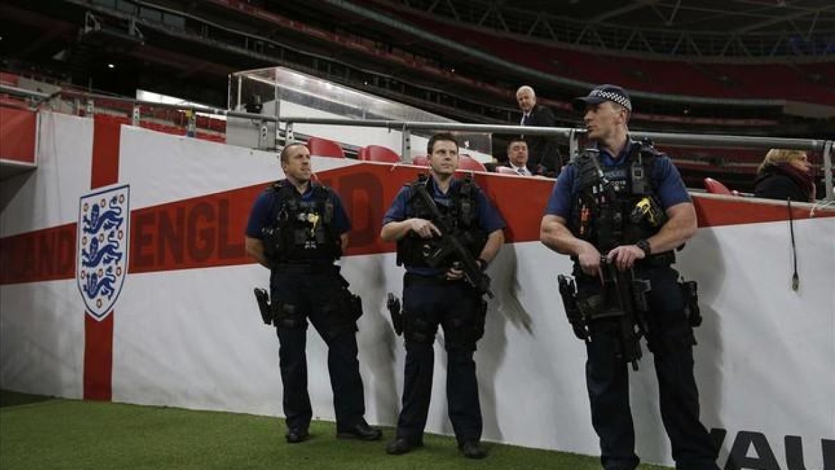 Policías británicos vigilan el interior del estadio londinense de Wembley.-AFP