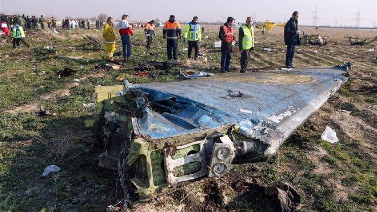 Técnicos supervisan el escenario donde explotó el avión ucraniano tras ser atacado por error por un misil iraní.-AFP / AKBAR TAVAKOLI