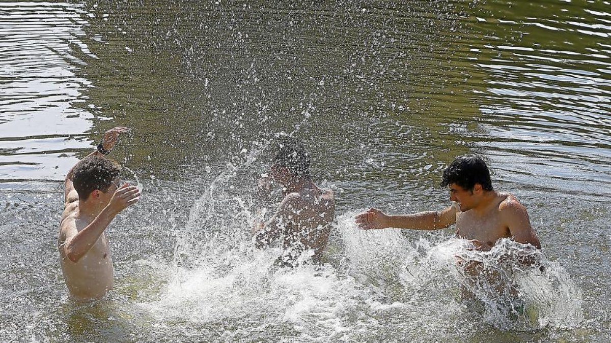 Jóvenes refrescándose durante la ola de calor en la Playa de las Moreras de Valladolid-J.M. LOSTAU