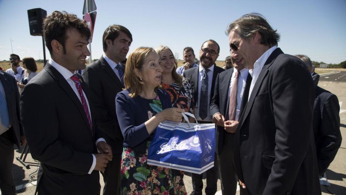 La ministra Ana Pastor asiste a la puesta en servicio de la nueva conexión viaria entre el parque logístico de Tordesillas y la A-6. en la imagen, Carlos Galicia, de la pastelería Galicia, regala a la ministra polvorones del Toro.-ICAL
