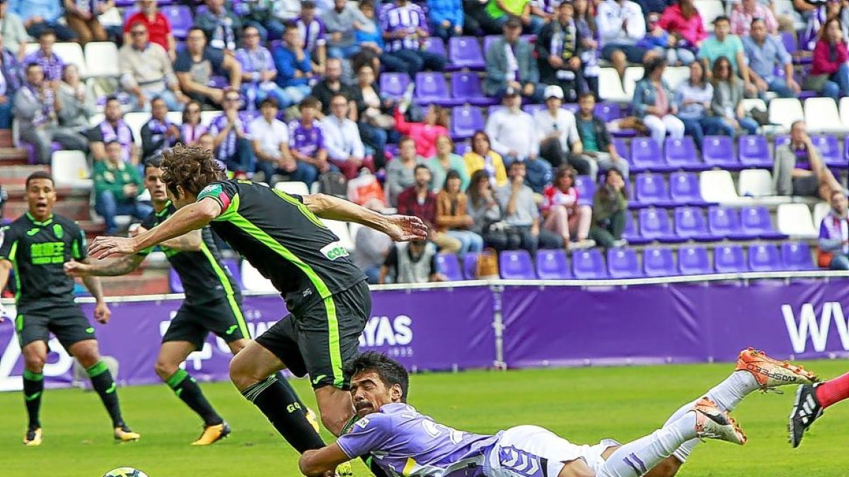 Iban Salvador cae en su intento por arrebatar el balón aBaena en el partido frente al Granada.-J. M. LOSTAU