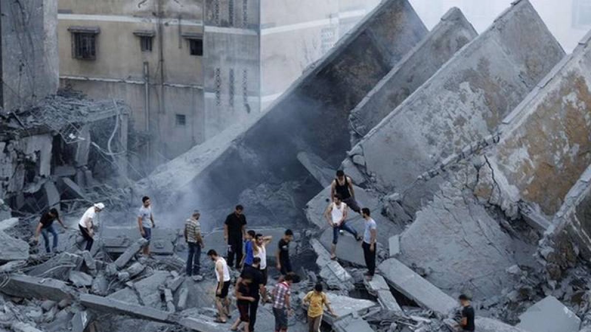 Palestinos inspeccionan los restos de Al-Basha, un edificio que fue destruido por un ataque aéreo israelí en Gaza-Foto: AFP PHOTO / MOHAMMED ABED
