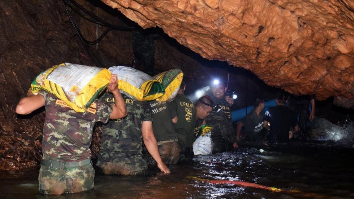Varios miembros de un equipo de rescate intentan drenar el agua de la cueva Tham Luang en Khun Nam Nang Non Forest Park (Tailandia).-ROYAL THAI ARMY HANDOUT (EFE)