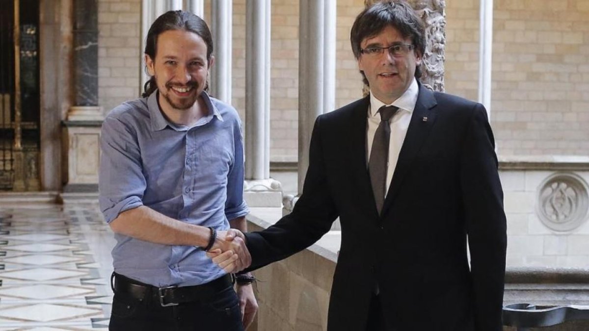 Pablo Iglesias y Carles Puigdemont, en el Palau de la Generalitat, en abril del año pasado.-AFP