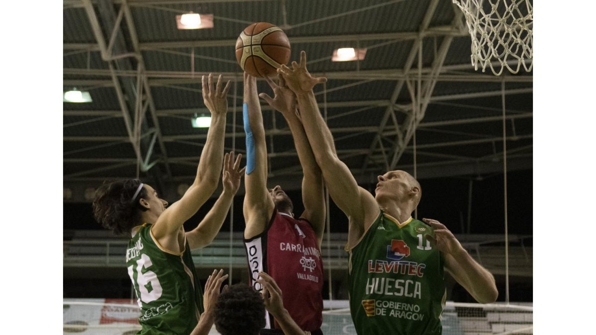 El siempre polivalente Federico luchando ayer por un rebote ante tres jugadores del Levitec Huesca.-LOF