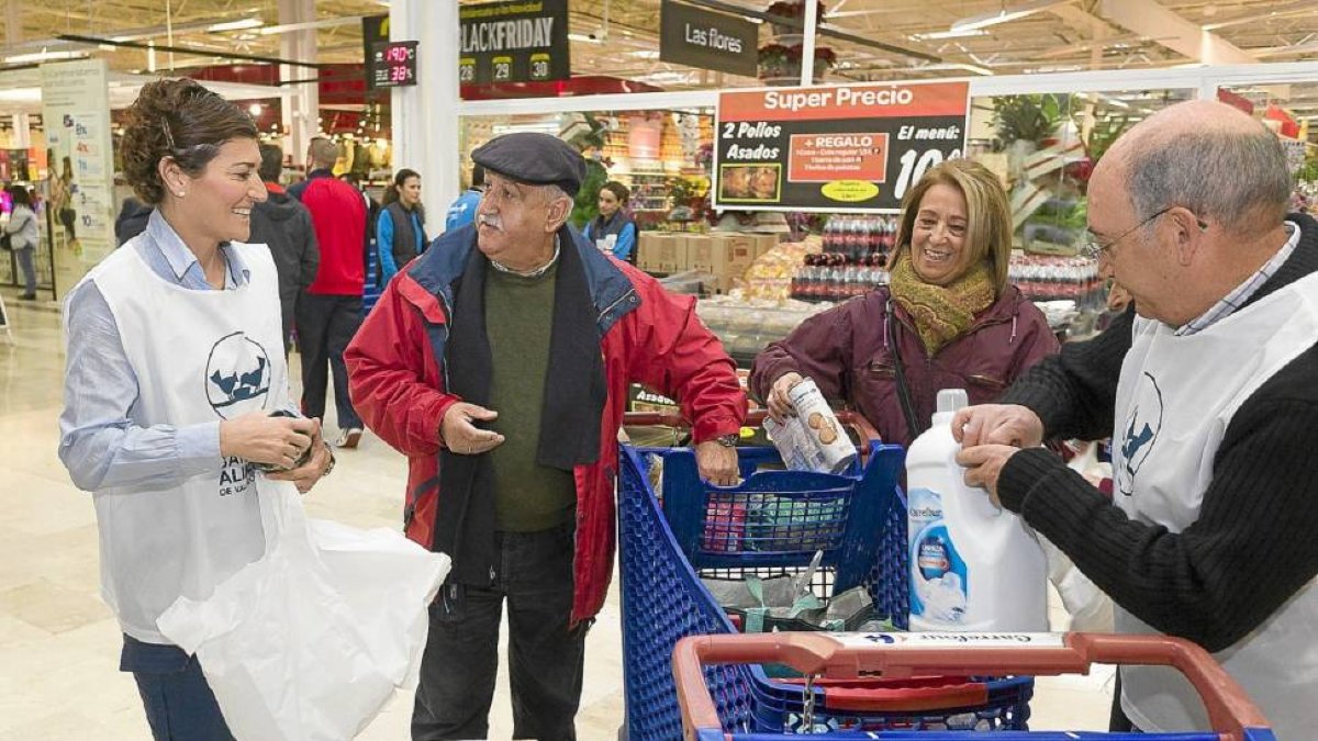 Dos personas entregan alimentos a los voluntarios durante la gran recogida celebrada el pasado mes de noviembre-Pablo Requejo