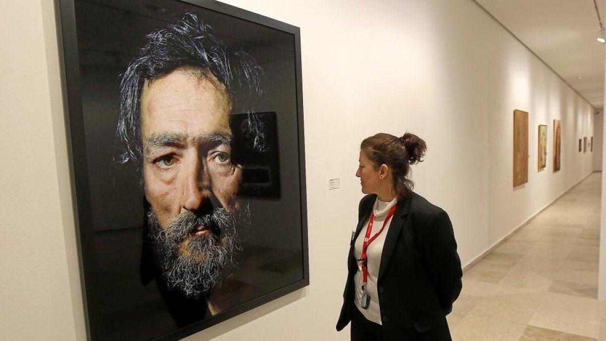 Una mujer contempla uno de los retratos de Pierre Gonnord.-J. M. LOSTAU