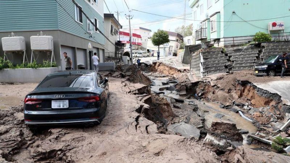 Un vehiculo permanece atrapado entre el lodo en una calle destruida tras el fuerte terremoto.-EFE / JIJI PRESS
