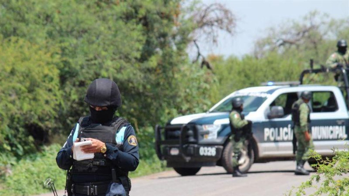 Policías prestan guardia en la zona donde un vehículo policial fue atacado por grupos armados, en Guanajuato (México).-EFE/ STR