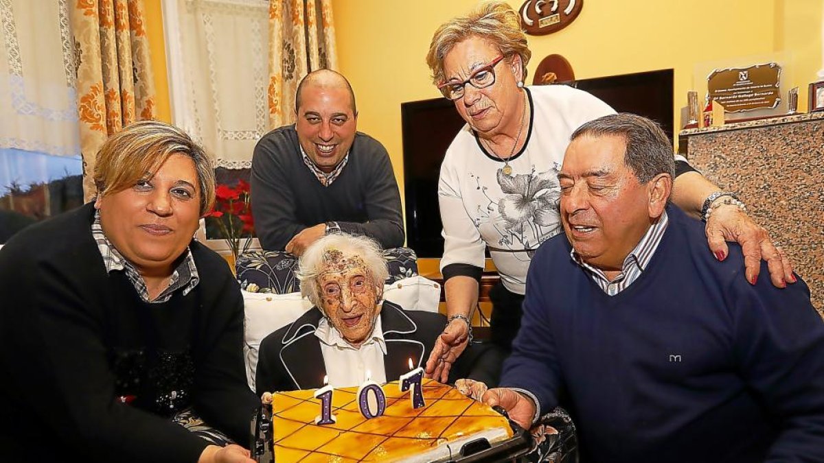 Bernarda sujetando la tarta de su cumpleaños acompañada por su hija, su yerno y dos de sus nietos .-J.M. LOSTAU