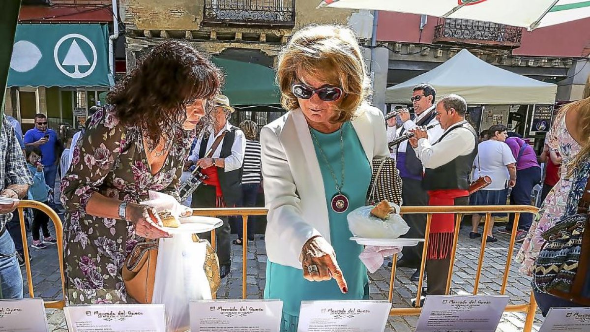 Dos mujeres degustan los diferentes tipos quesos presentes en el mercado.-MIGUEL ÁNGEL SANTOS