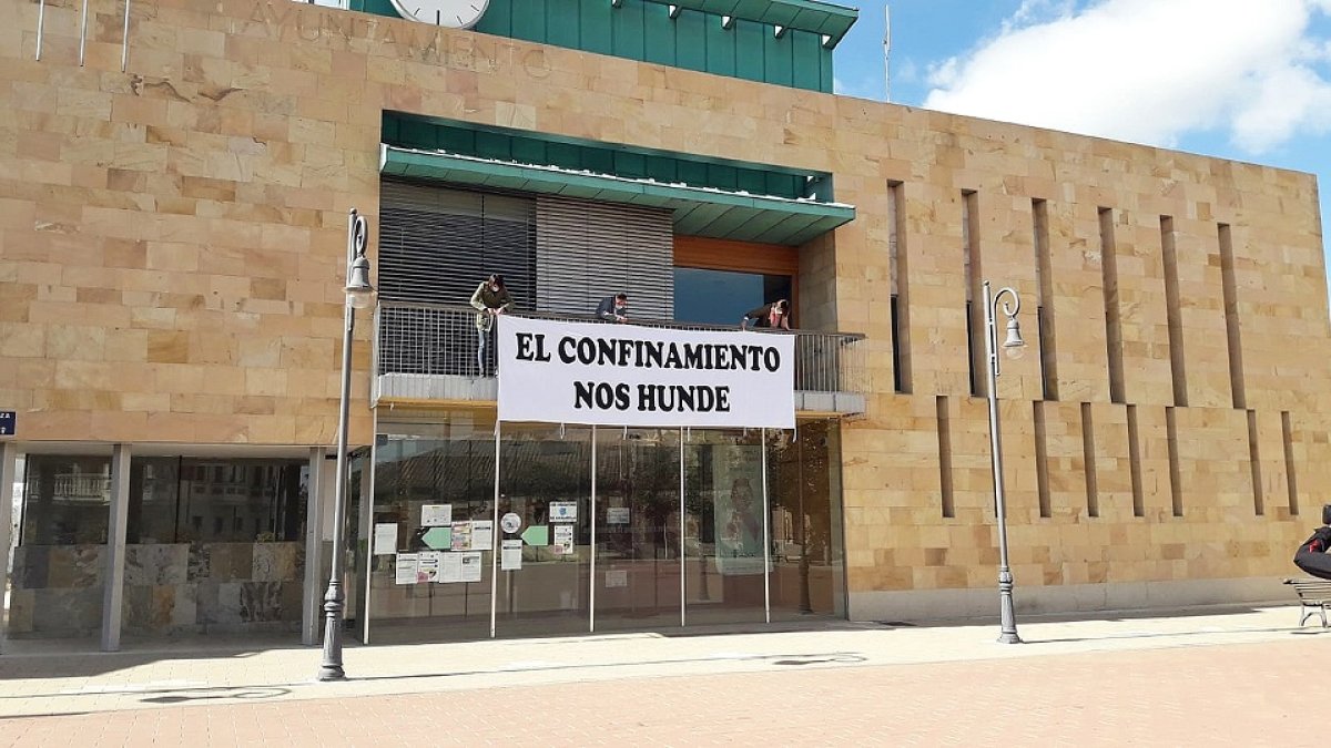 Alfonso Romo coloca la pancarta en el Ayuntamiento. LA 8 DE VALLADOLID