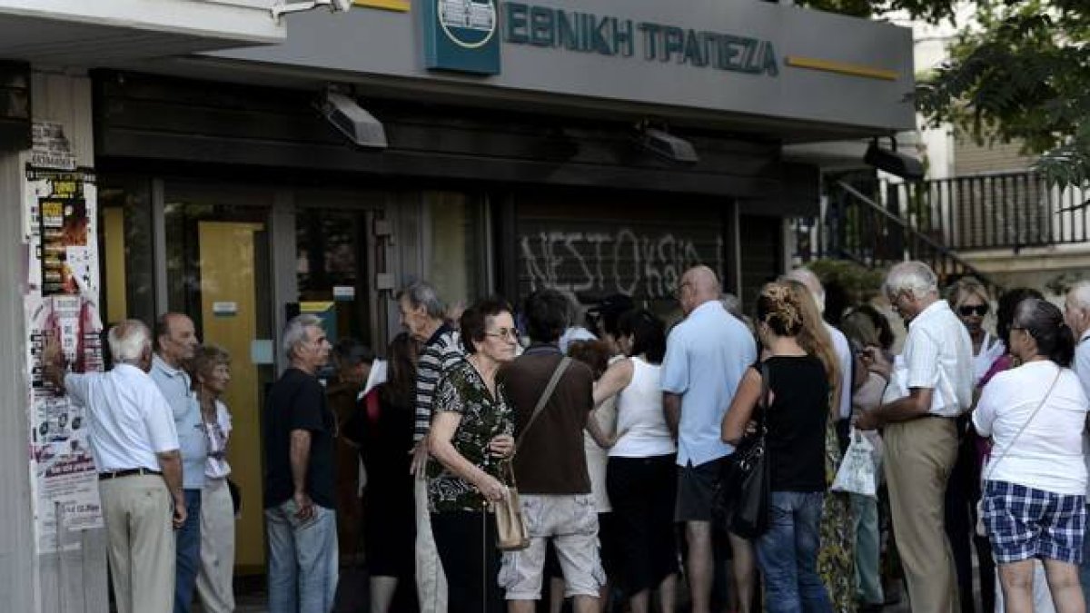 Ciudadanos griegos esperando la apertura de los bancos.-Foto: AFP / ARIS MESSINIS