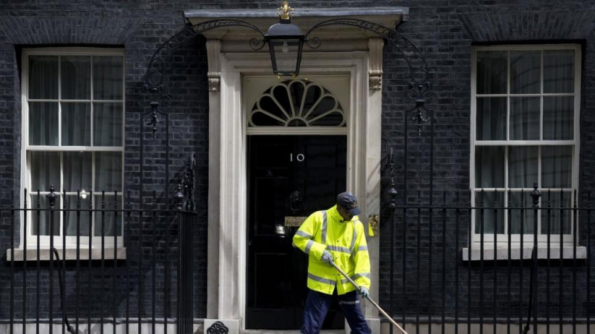 Un barrendero limpia la entrada del número 10 de Downing Street, la sede del primer ministro británico.-JUSTIN TALLIS / AFP