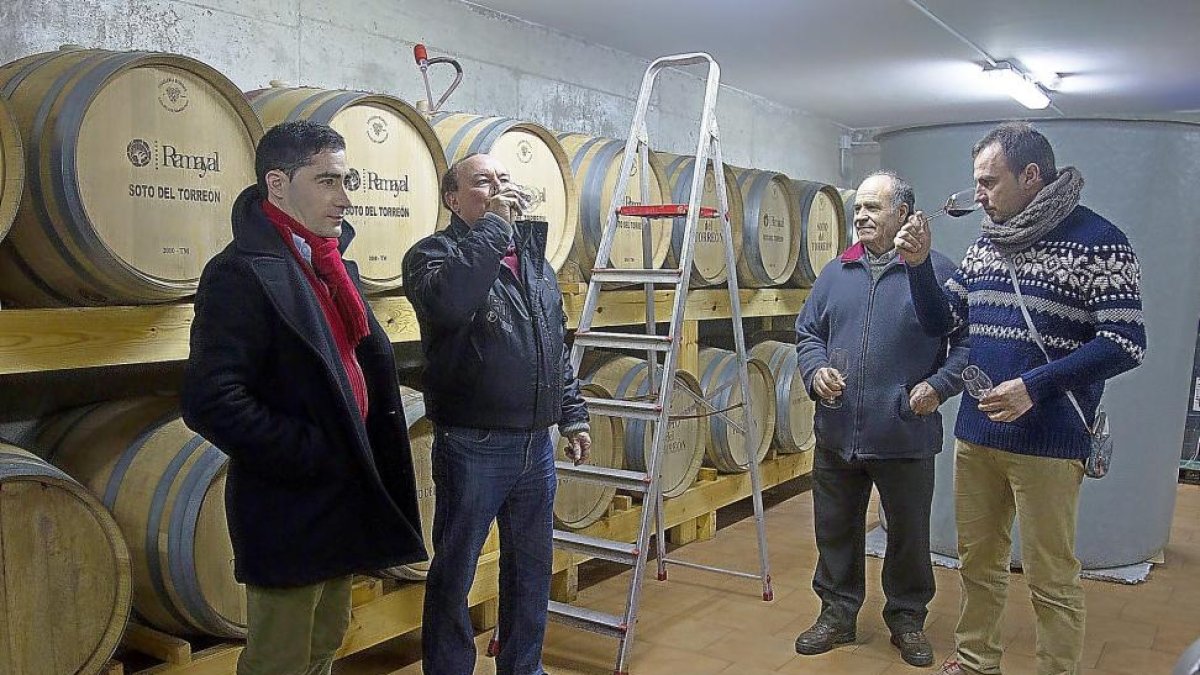 Los bodegueros y enólogos Rubén Gago (i), Antonio Ferrero, a su lado, y David Mendieta (d) catan unos vinos en barrica.-M. D.