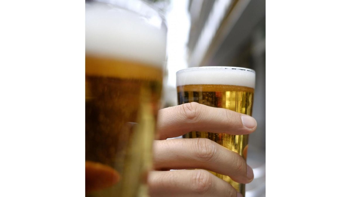 Dos consumidores de cerveza levantan su vaso.-ENRIQUE CARRASCAL