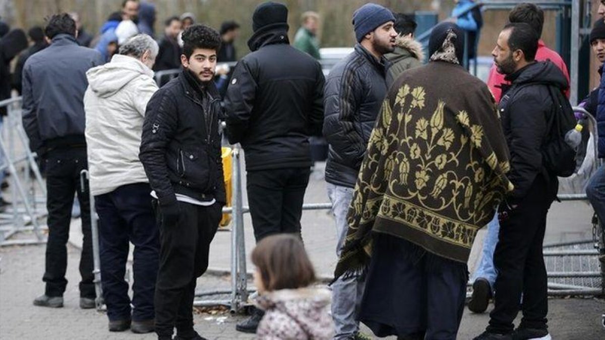 Migrantes esperan para registrarse frente a la oficina federal de migración y refugiados del distrito de Spandau, en Berlín (Alemania).-REUTERS / FABRIZIO BENSCH