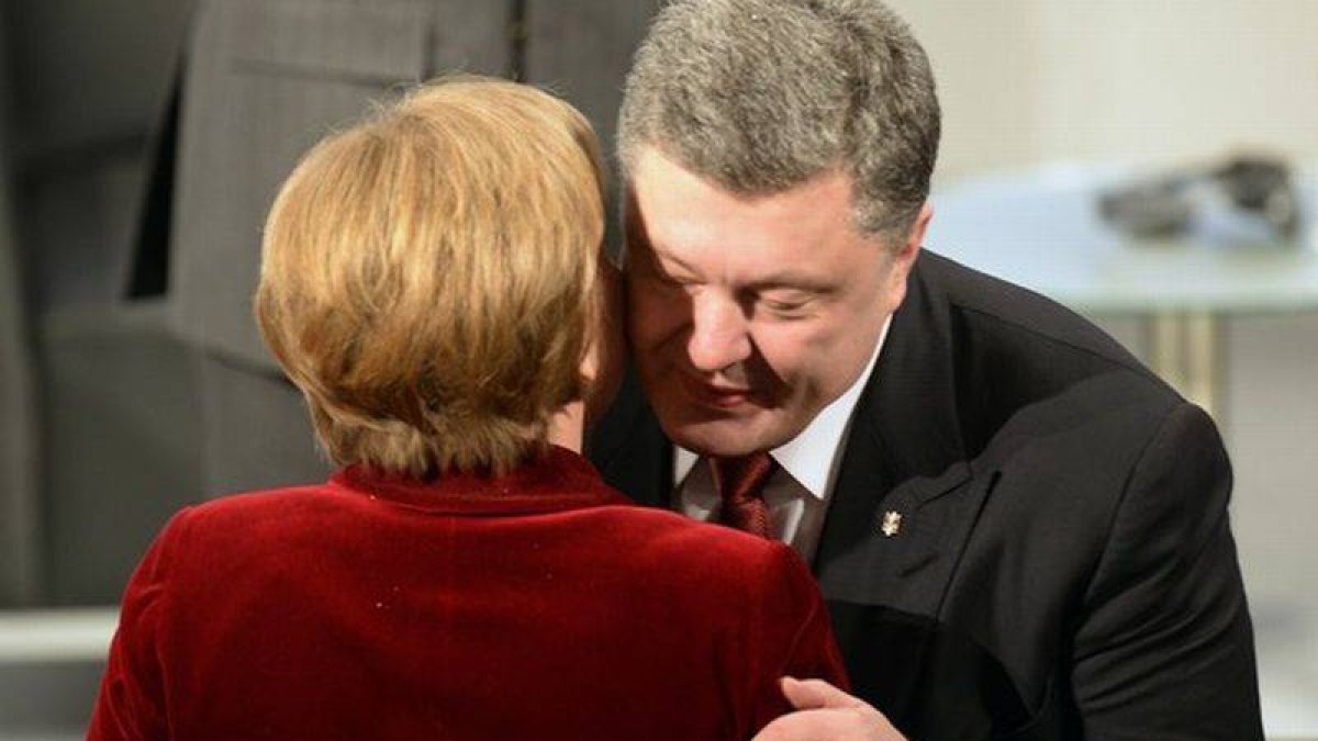 La cancillera Angela Merkel y el presidente de Ucrania, Petro Poroshenko, se saludan en Múnich.-Foto: THOMAS KIENZLE / AFP