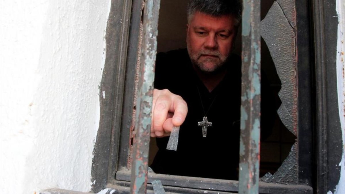 Un sacerdote evalúa los daños ocasionados en una de las iglesias atacadas.-/ REUTERS