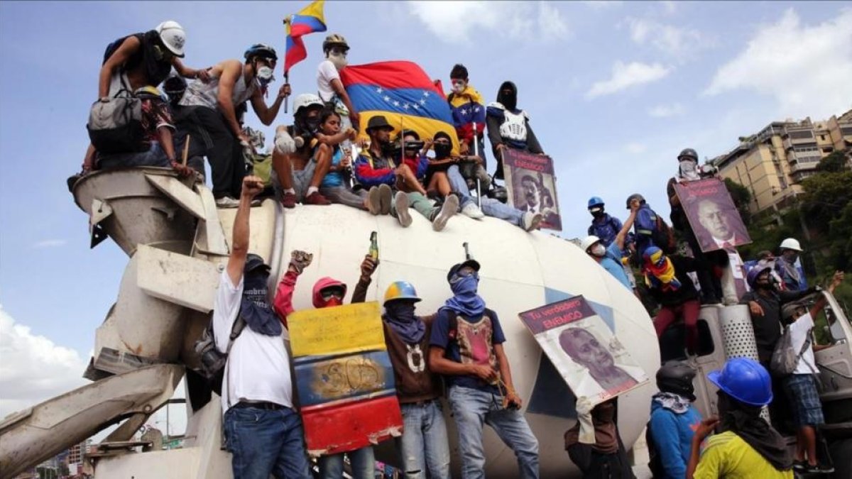 El violinista venezolano Willy Arteaga (arriba) toca junto a manifestantes sobre una mezcladora de cemento durante una protesta de este pasado sabado en Caracas.-MAURICIO DUEÑAS CASTAÑEDA