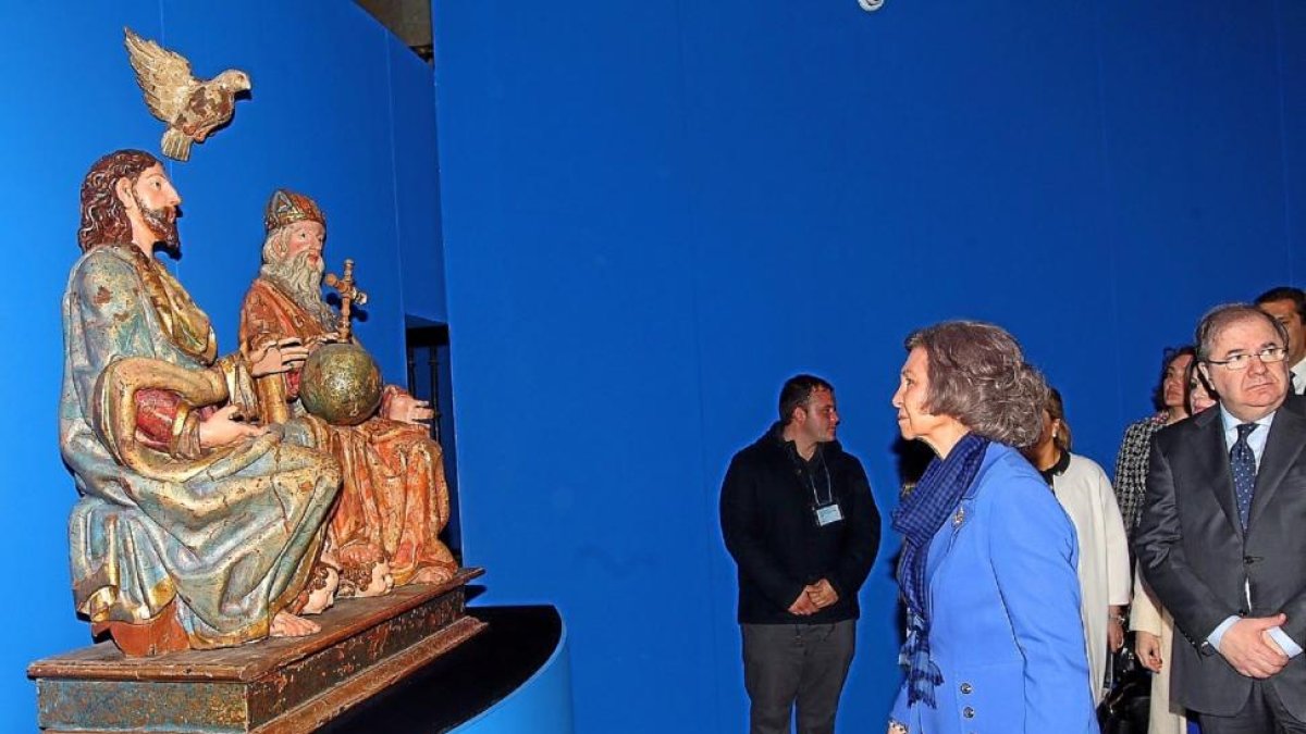 La Reina Sofía, acompañada por el presidente Herrera, contempla una de las obras expuestas en la muestra.-CASA REAL