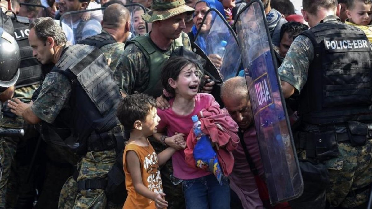 Dos niños lloran en un enfrentamiento entre inmigrantes y policía en la frontera de Grecia y Macedonia, en el 2015.-EFE / GEORGI LICOVSKI