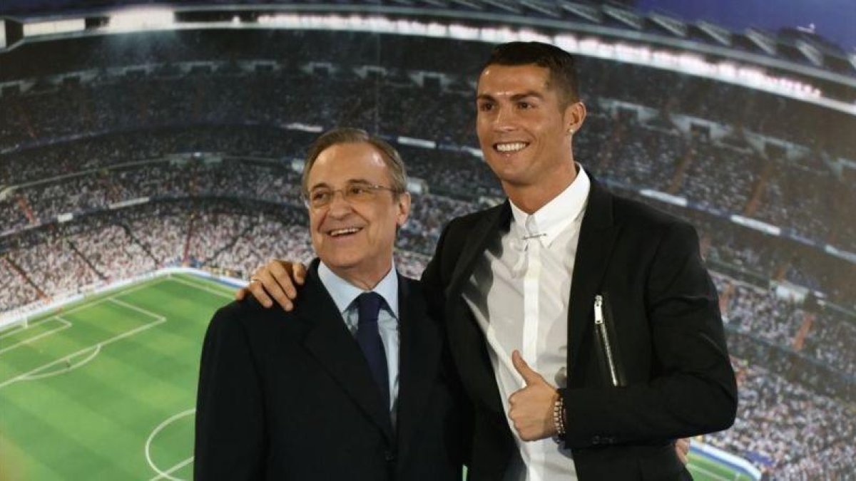 Cristiano Ronaldo, abrazado a Florentino Pérez el día de la presentación de su renovación.-AFP / GERARD JULIEN