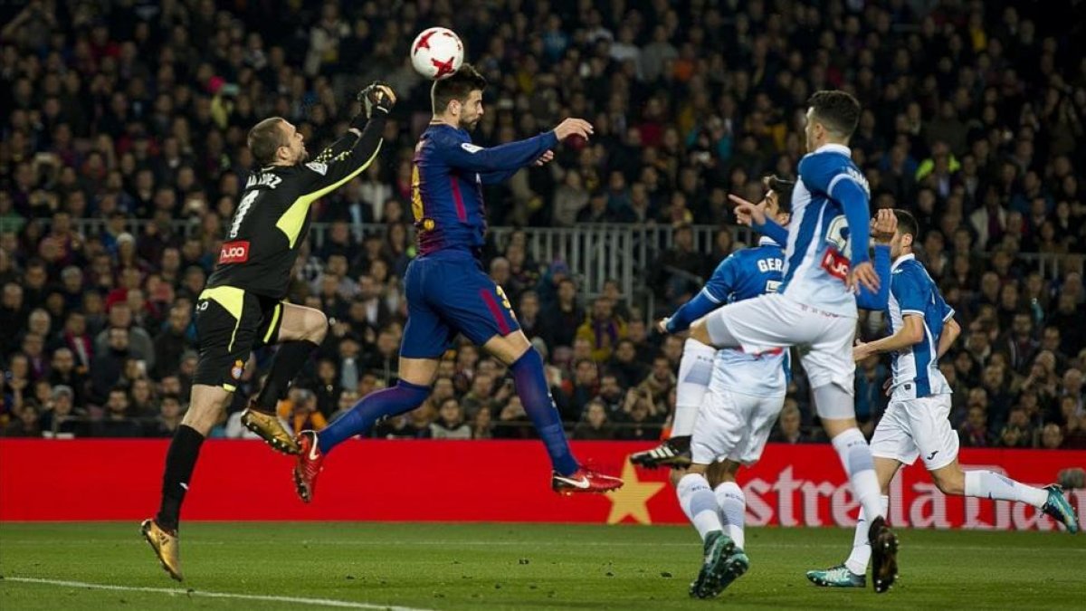 Gerard Piqué cabecea un balón, ante el Espanyol.-JORDI COTRINA