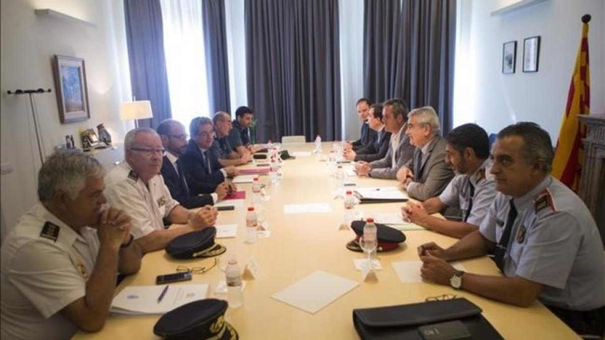 El delegado del Gobierno, Enric Millo, presidiendo la reunión de este martes con el conseller de Interior, Joaquim Forn, junto a todos los mandos policiales de las administraciones: Mossos dEsquadra, Guardia Civil y Policía Nacional.-QUIQUE GARCÍA