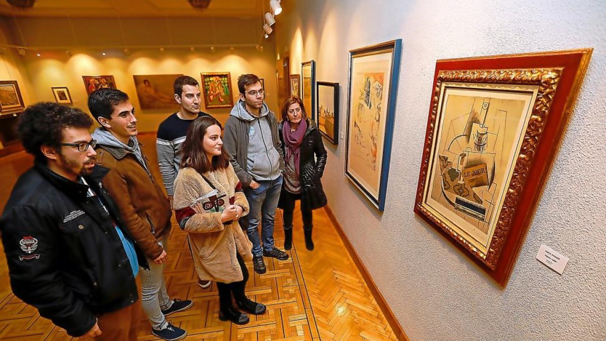 Un grupo observa una litografía de Picasso.-J.M. LOSTAU