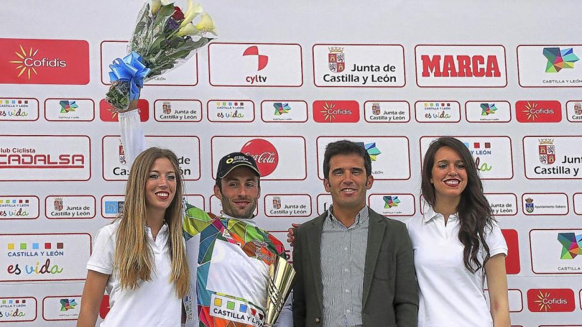 El vencedor de la Vuelta a Castilla y León posa en el podio junto al director general de Deportes de la Junta, Alfonso Lahuerta, y dos azafatas-ICAL
