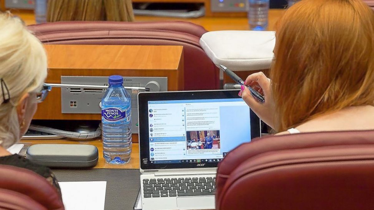 Dos procuradoras de Podemos comentan la actualidad delante de un ordenador.-P. REQUEJO